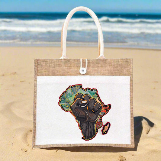 An embroidered jute tote featuring a raised fist over a silhouette of Africa, accompanied by embroidered foliage.