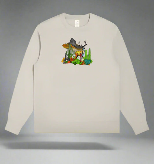 Embroidered sweatshirt with a design of a mountain deer among snow-dusted pines and wild flowers.