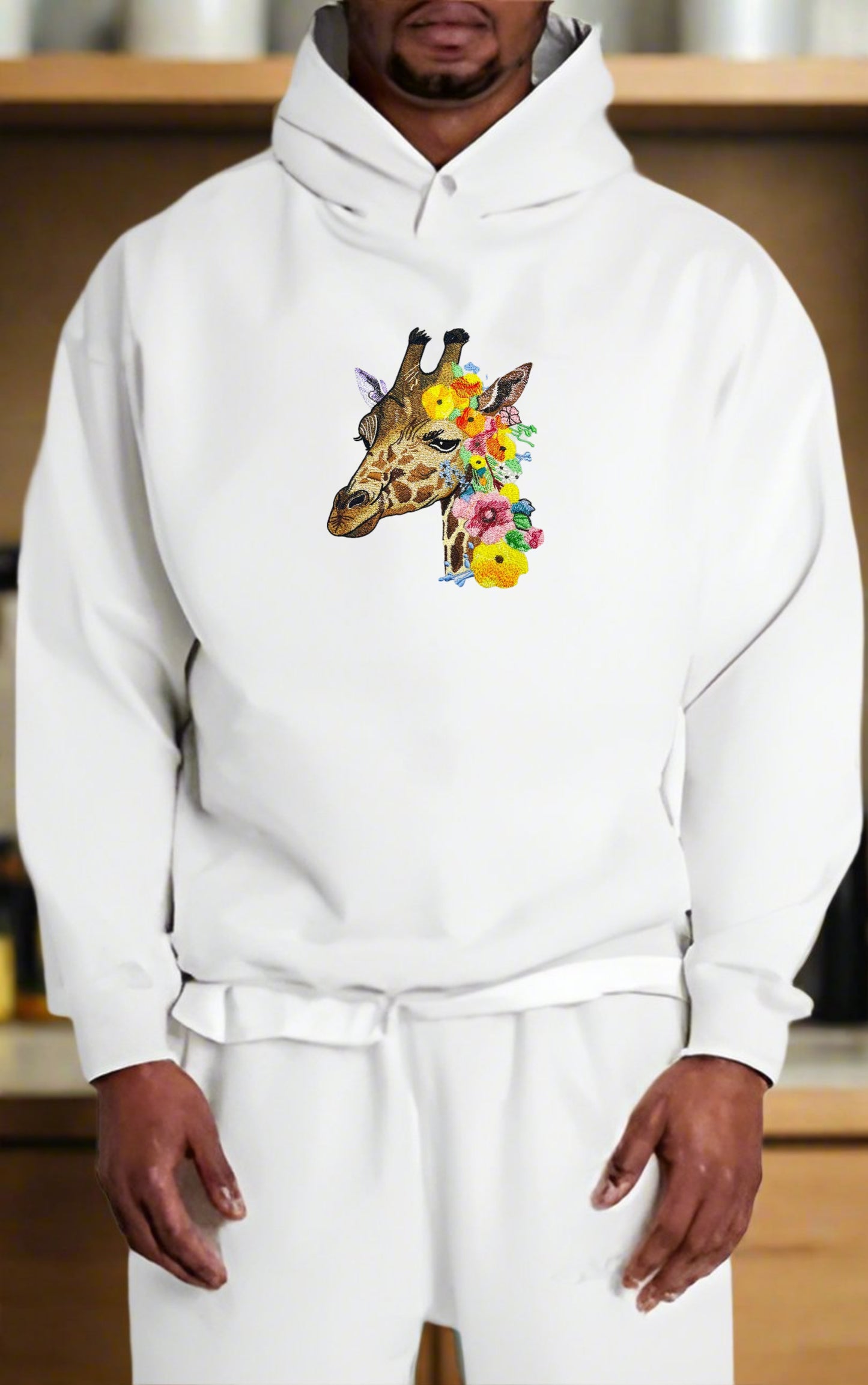 Embroidered hoodie featuring a giraffe with wildflower patterns.