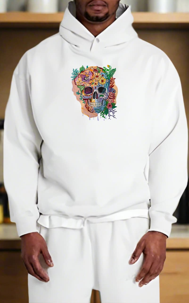 Person wearing a white hoodie with a colorful skull design on a wooden shelf background