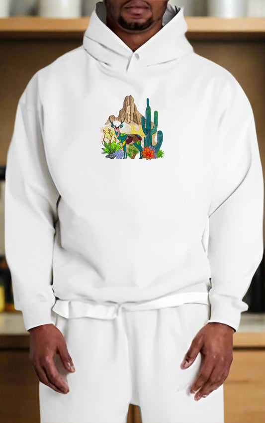 Embroidered hoodie featuring a mountain deer and cactus design on a white background.