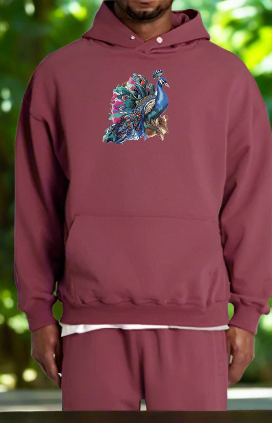 Maroon hoodie with a colorful peacock design on a blurred green background