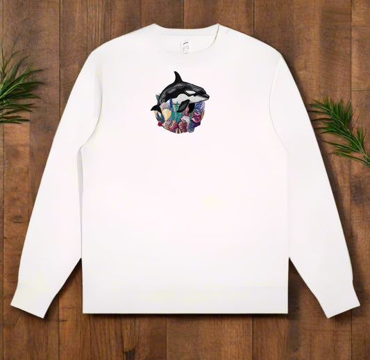 White long-sleeve sweatshirt with a Orca Reef Garden Embroidery – Ocean Spirit design on a wooden surface.