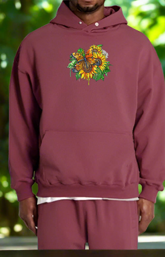 An embroidered hoodie with a design featuring a butterfly and floral elements on a sunflower motif.