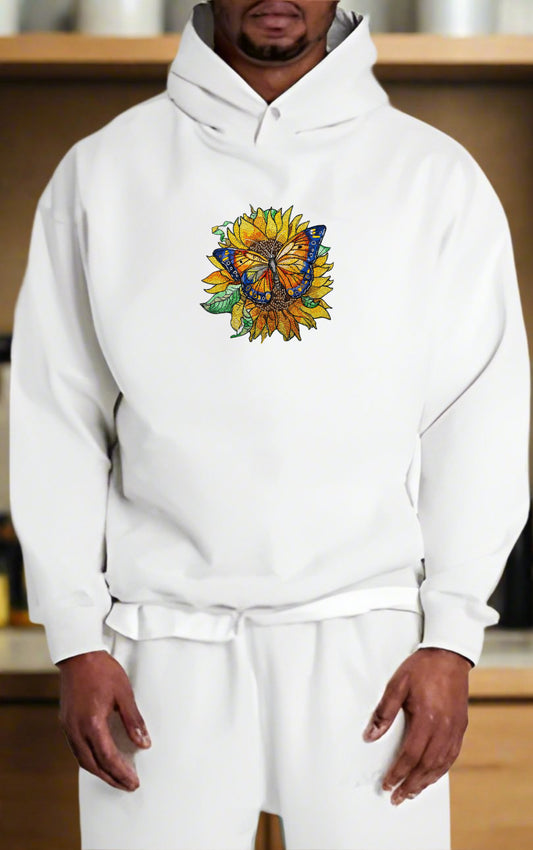 Embroidered hoodie featuring a colorful butterfly sitting on a sunflower with surrounding green leaves.