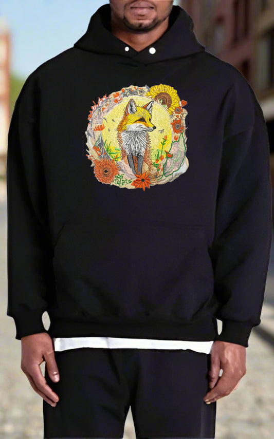 Embroidered hoodie featuring a golden fox surrounded by floral patterns, predominantly in shades of yellow, orange, and green.