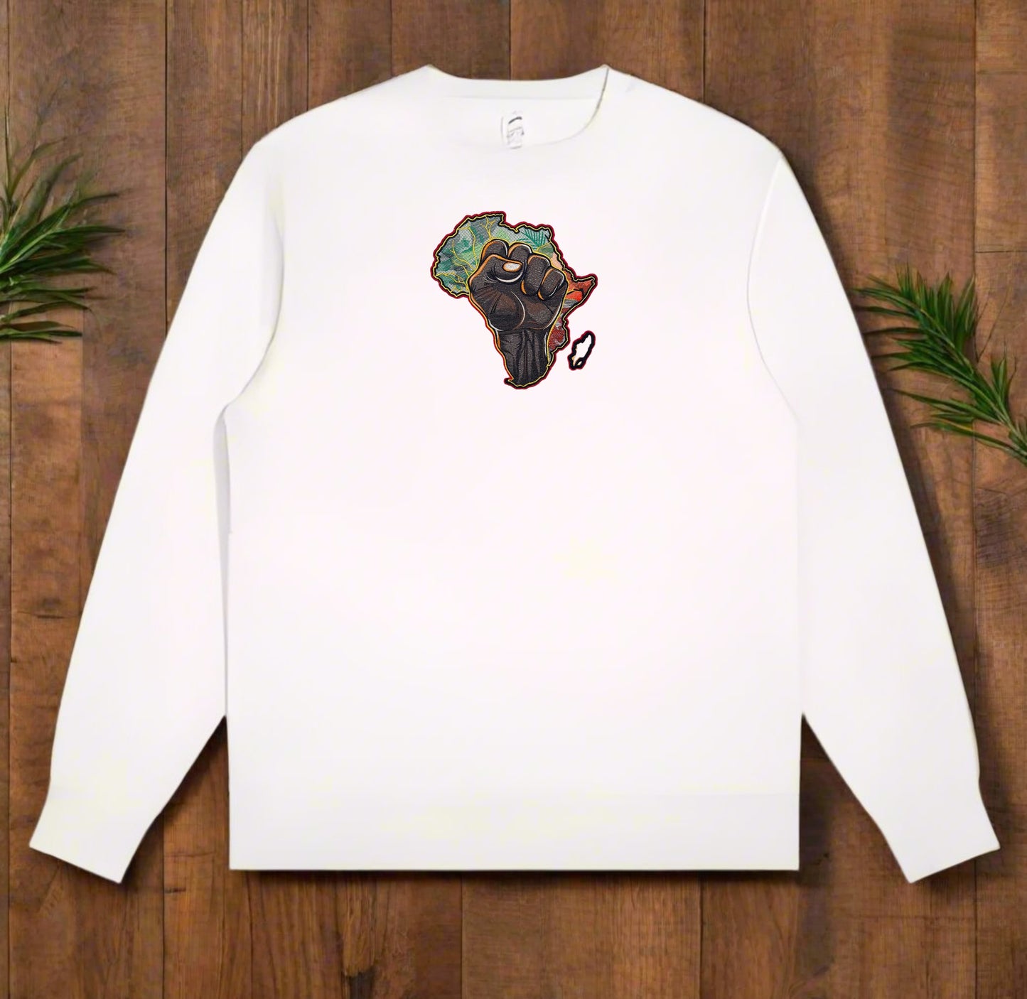 White long-sleeve shirt with a colorful Africa map design on a wooden surface.
