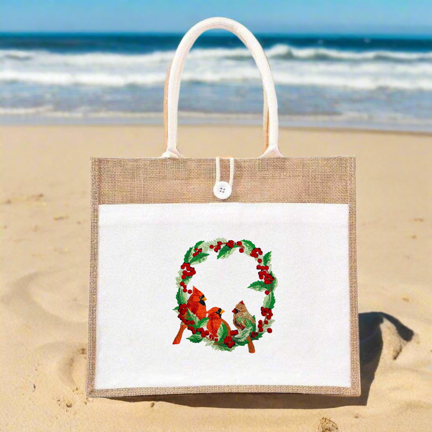 Embroidered design featuring two red cardinals among green foliage with red berries on a white background.