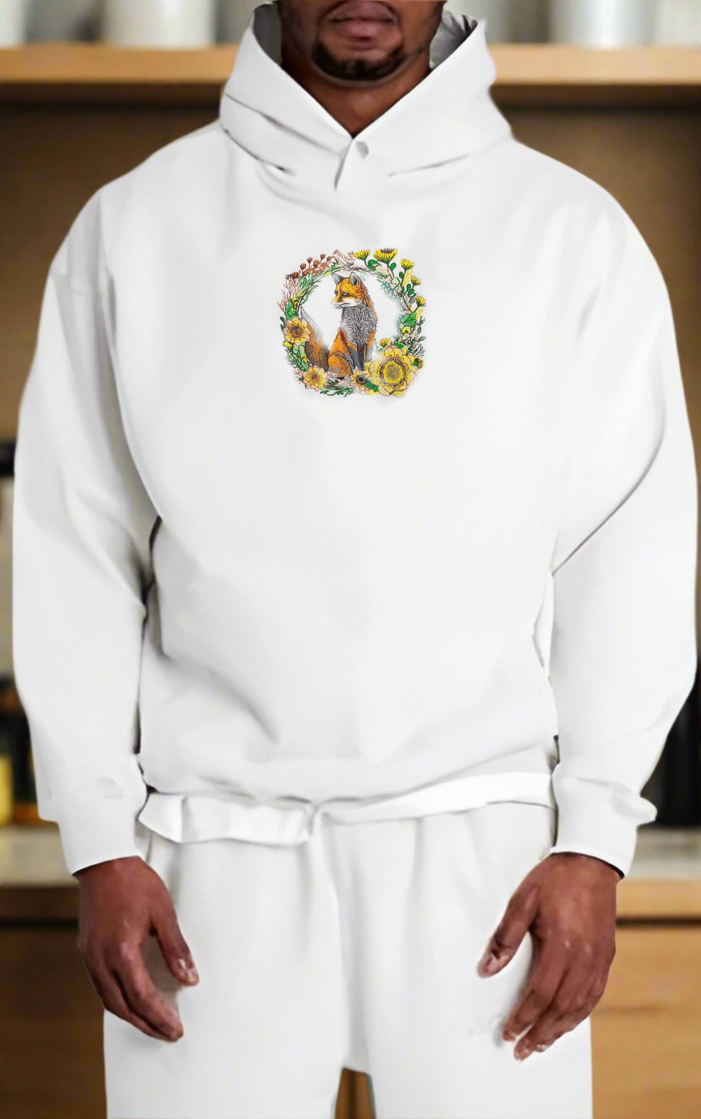 Person wearing a white hoodie with a floral design and animal illustration.