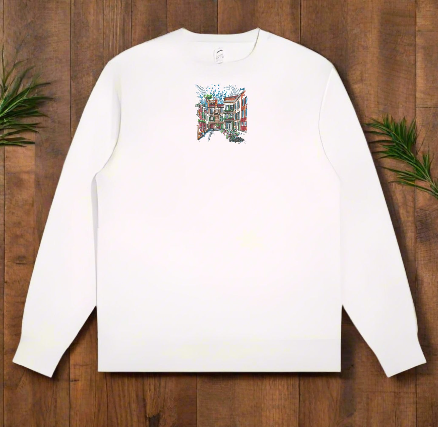 White long-sleeve sweatshirt with a Urban Cityscape Embroidery – Creative Street on a wooden surface