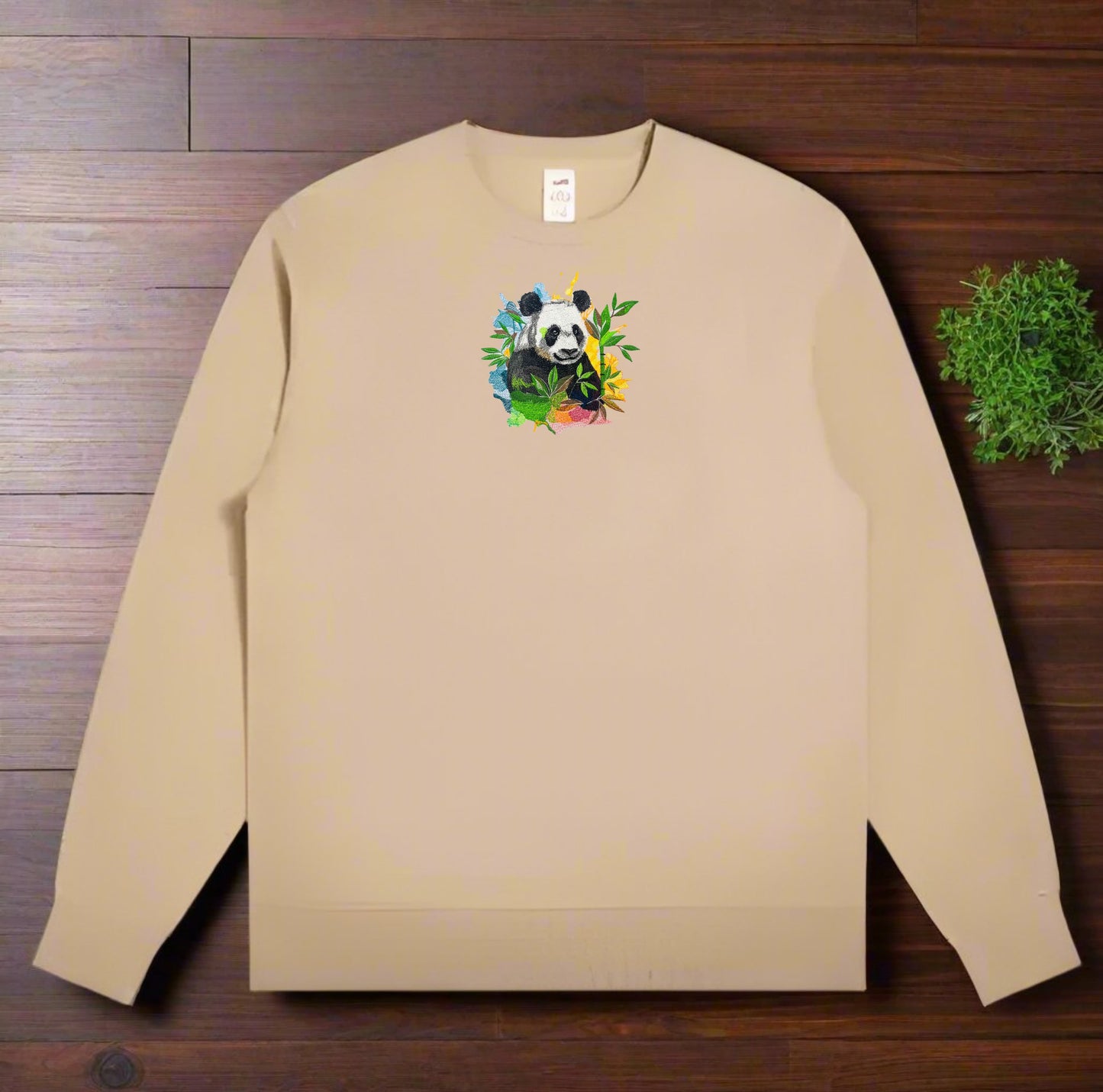 Beige sweatshirt with a panda design on a wooden surface