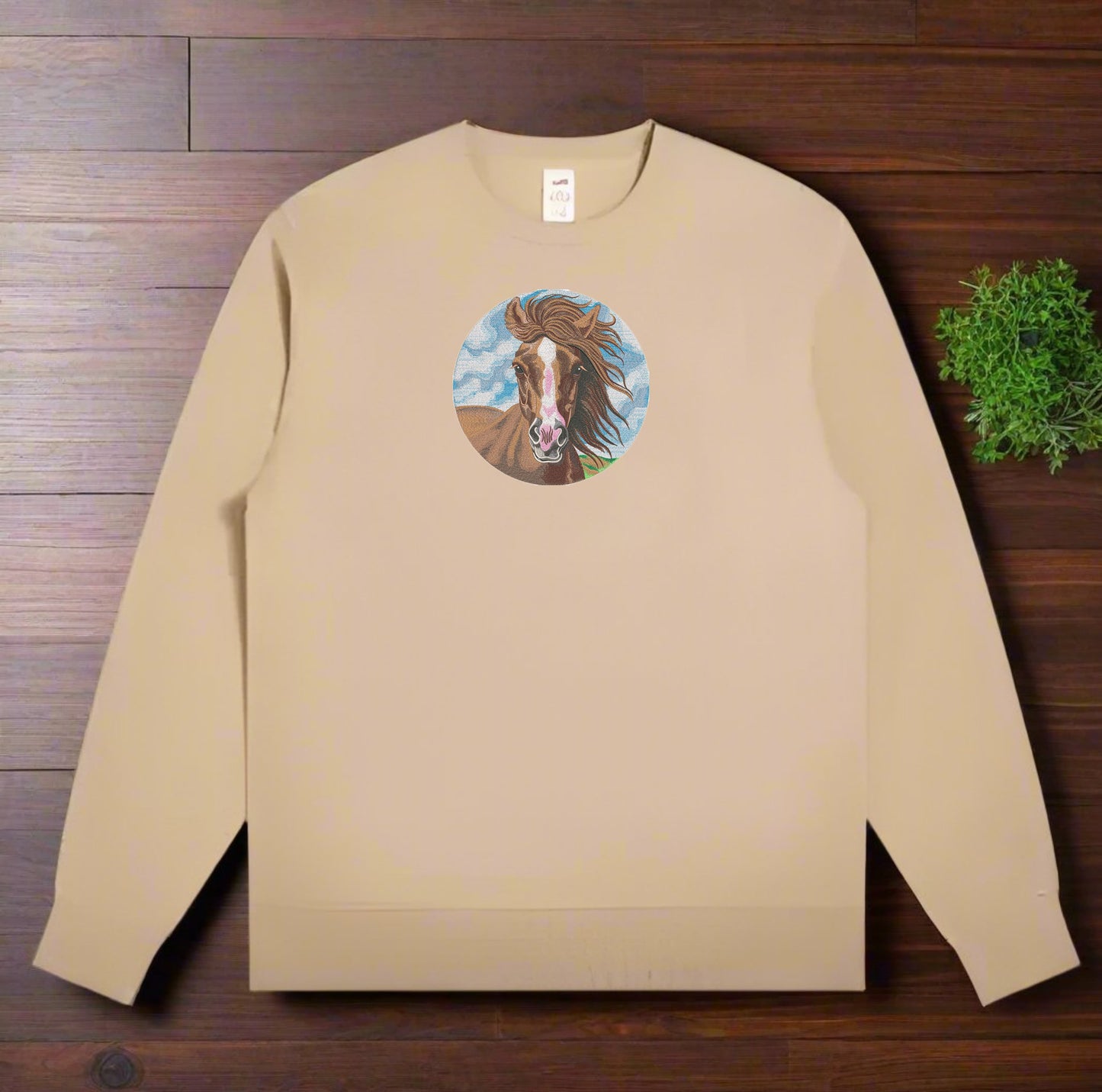 Beige sweatshirt with a Wild Horse Portrait Embroidery – Free Spirit on a wooden surface