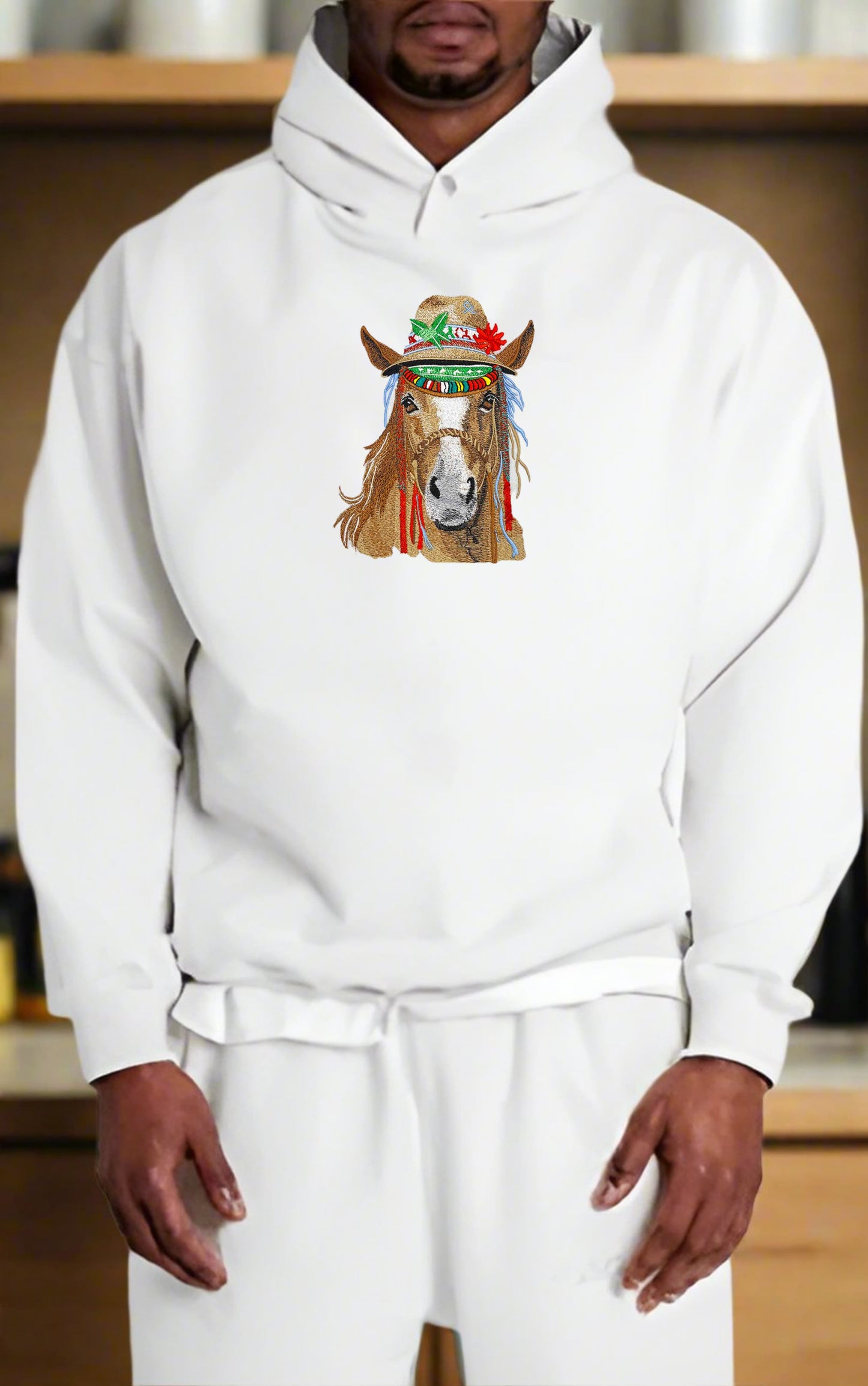 Person wearing a white hoodie with a horse graphic design on a blurred indoor background