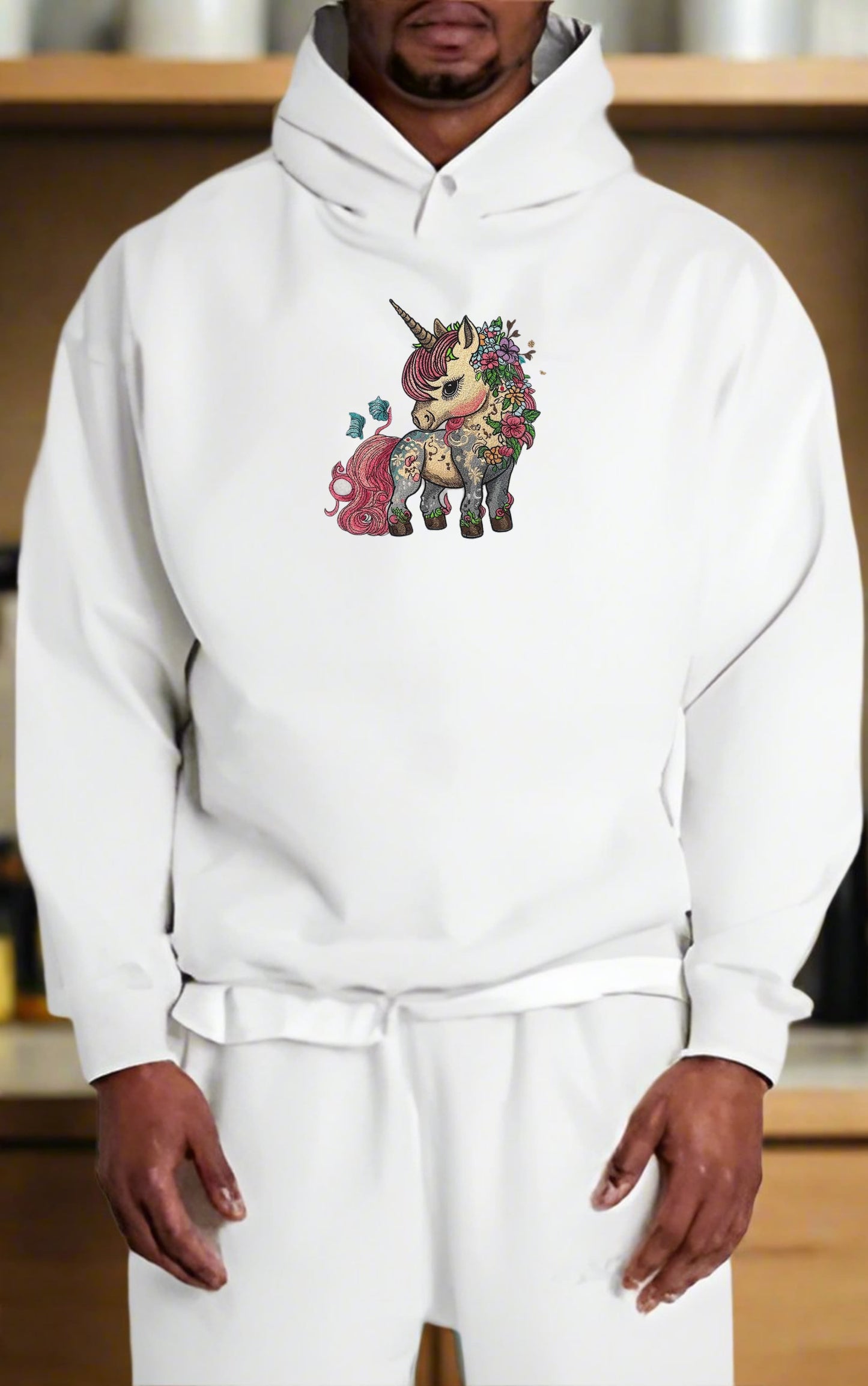Person wearing a white hoodie with a colorful unicorn design.