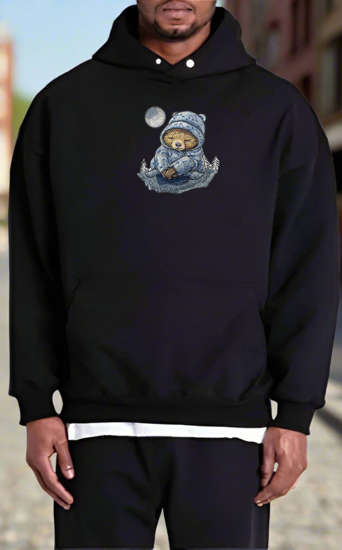 Person wearing a black hoodie with a sloth design on a blurred background