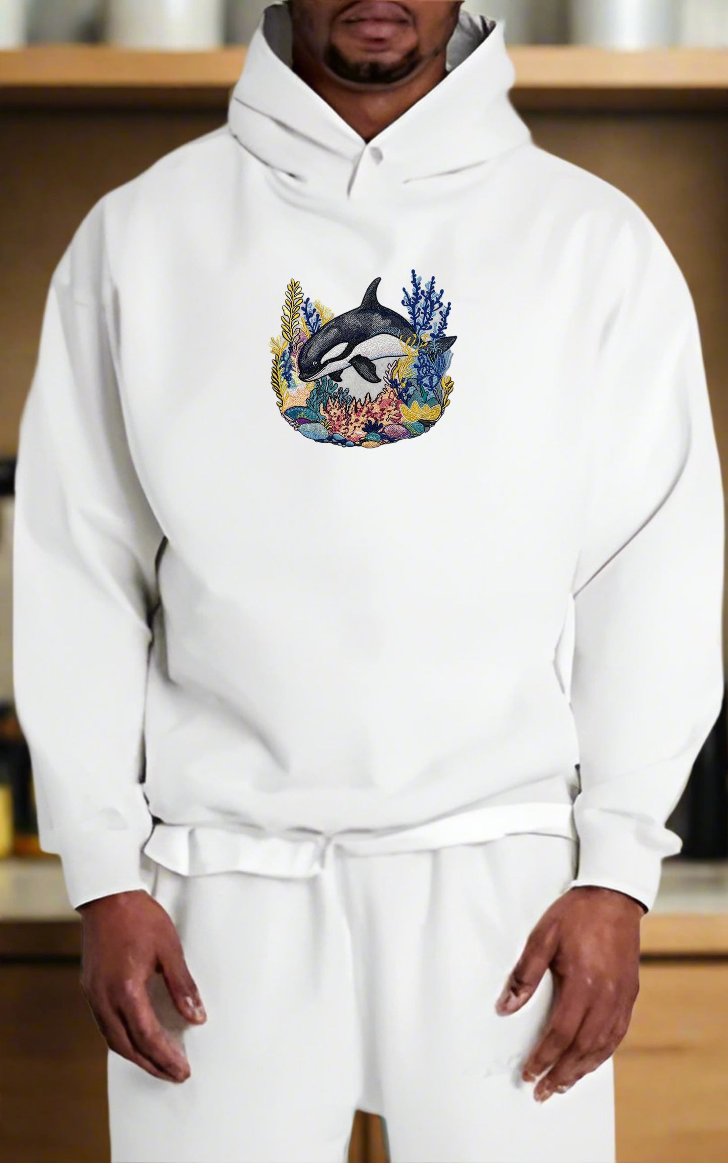 Person wearing a white hoodie with a dolphin design on a wooden shelf background