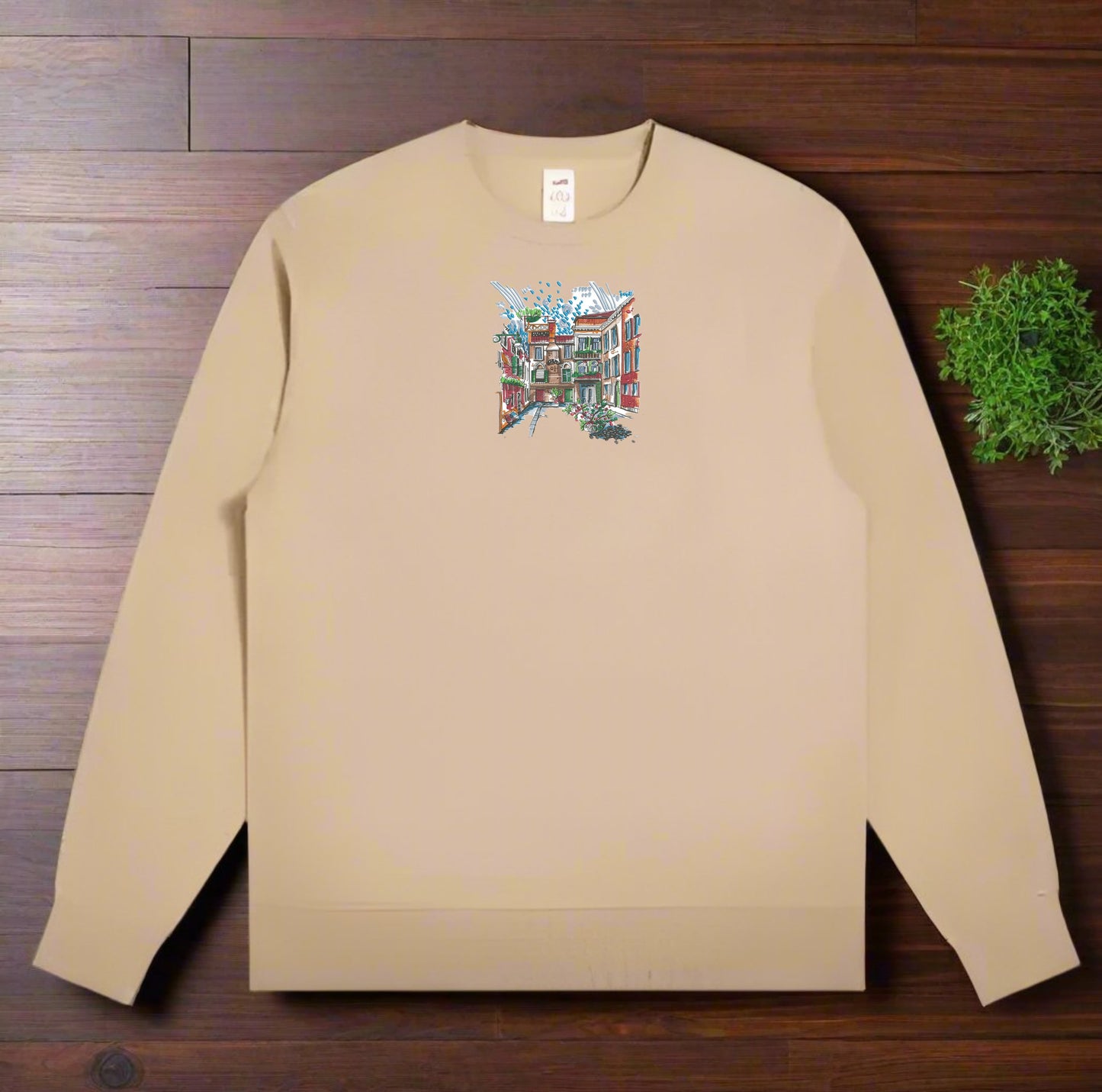 Beige long-sleeve sweatshirt with a Urban Cityscape Embroidery – Creative Street on a wooden surface