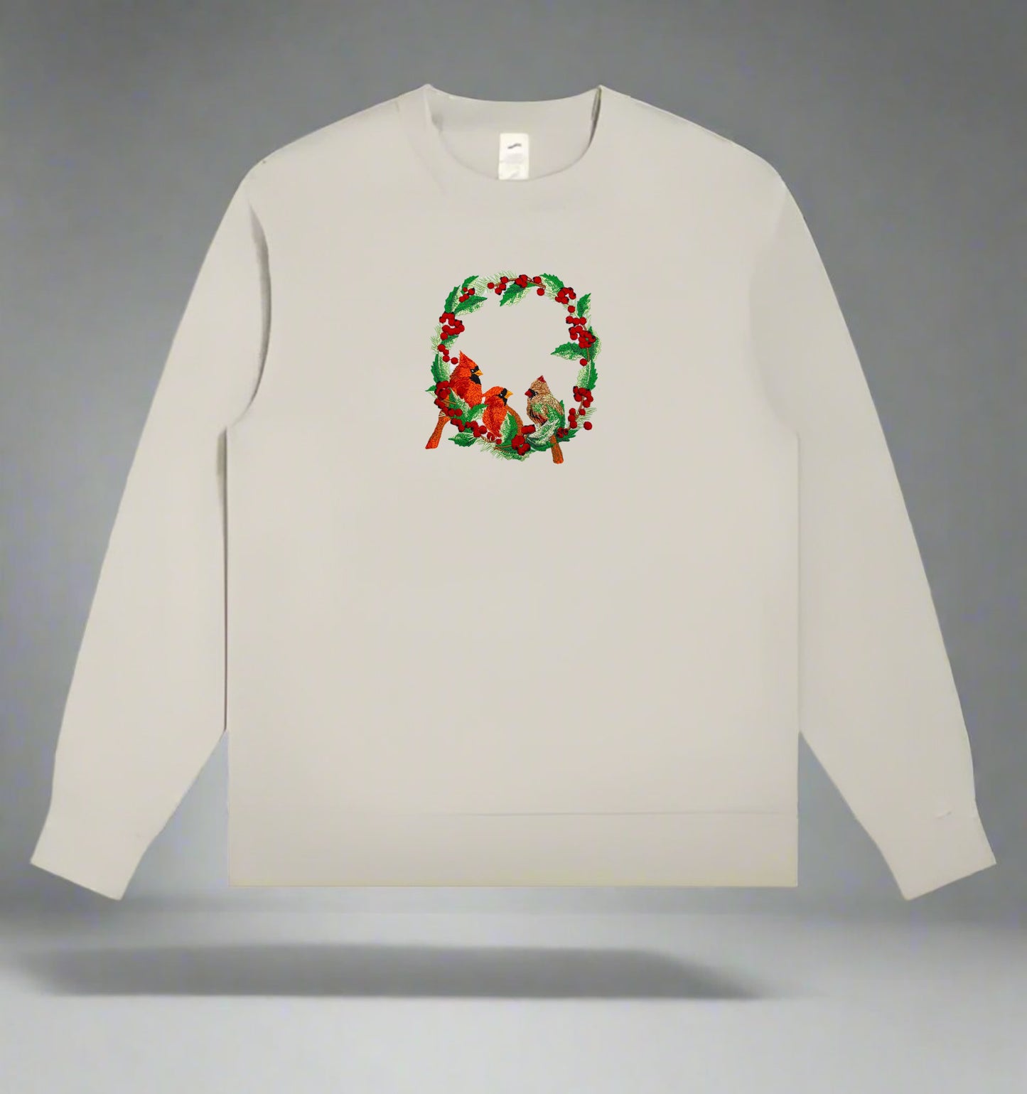 Embroidered design featuring two red cardinals among green foliage with red berries on a white background.