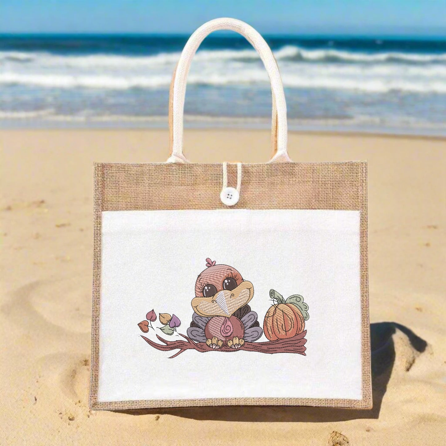 Jute bag with a cute animal design on a sandy beach with ocean in the background