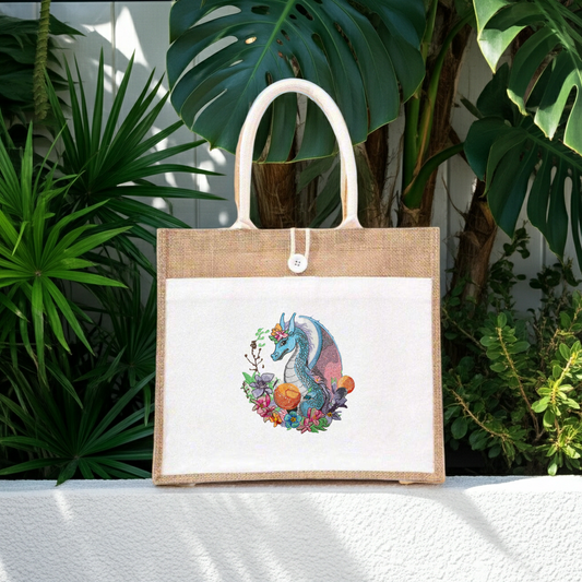 Tote bag with a colorful dragon design on a white background, surrounded by green plants.