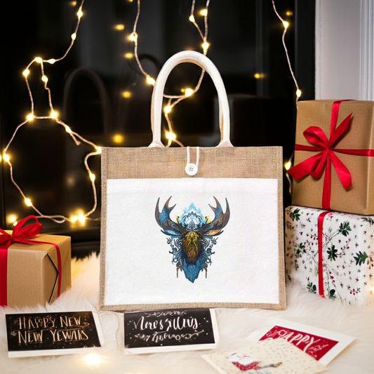 Natural jute tote handbag featuring a mystic blue moose with Nordic antlers embroidery design, styled on a fluffy rug with string lights, wrapped gifts, and holiday cards.