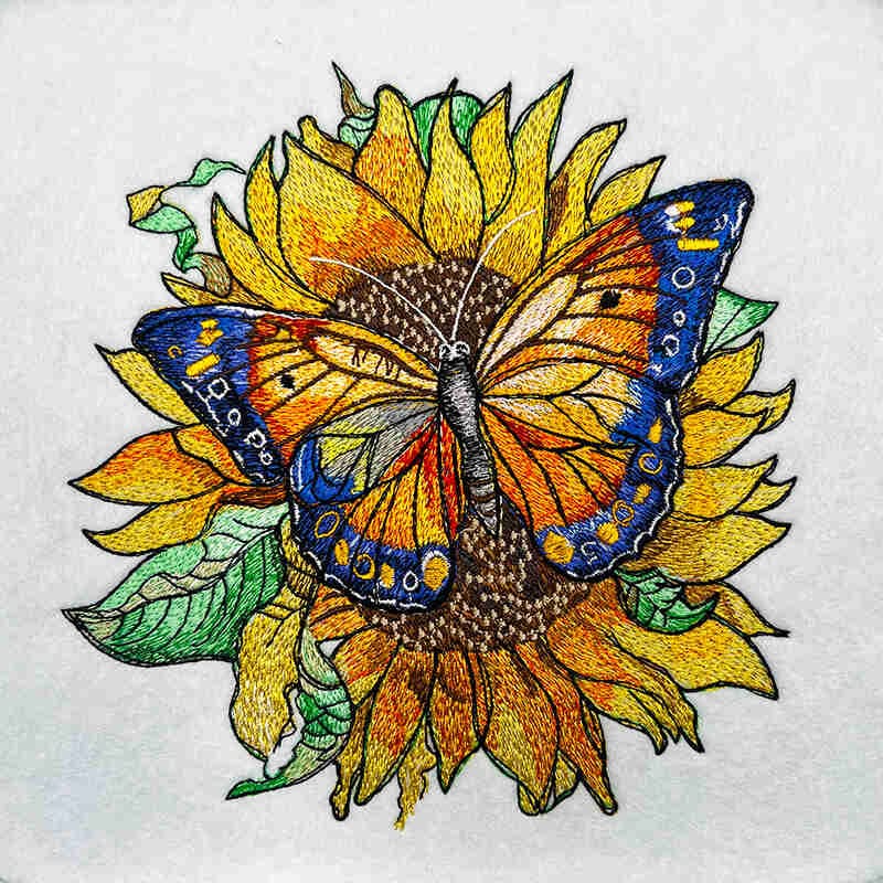 Butterfly on a sunflower with embroidered details on white fabric