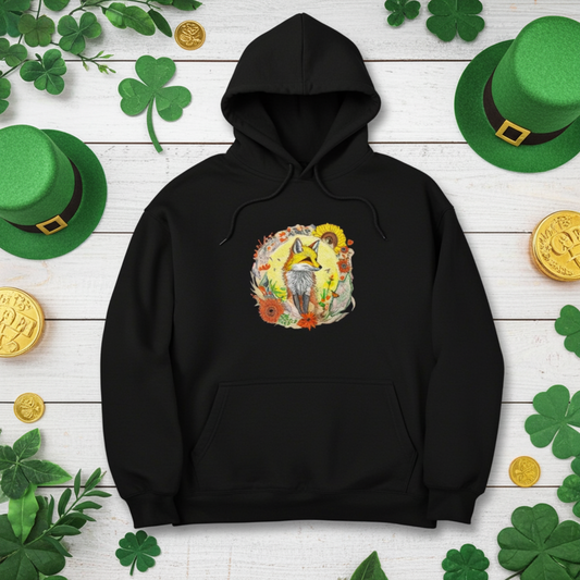 Black premium hoodie with Sunshine Fox & Sunflower embroidery featuring a fox framed by sunflowers and wildflowers in warm tones, styled on a wooden background with shamrock decorations, green hats, and gold coins, original EmbroMania artwork.