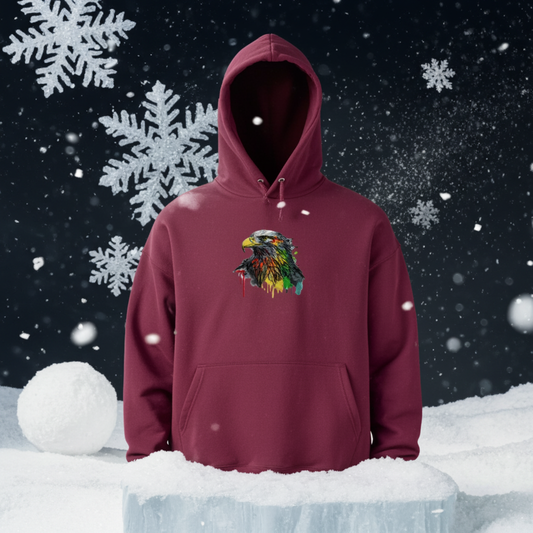 Burgundy hoodie featuring a vivid eagle head embroidery design with a multicolor paint-splash effect and drip accents on the chest, shown on a mannequin against a snowy winter background, original EmbroMania artwork.