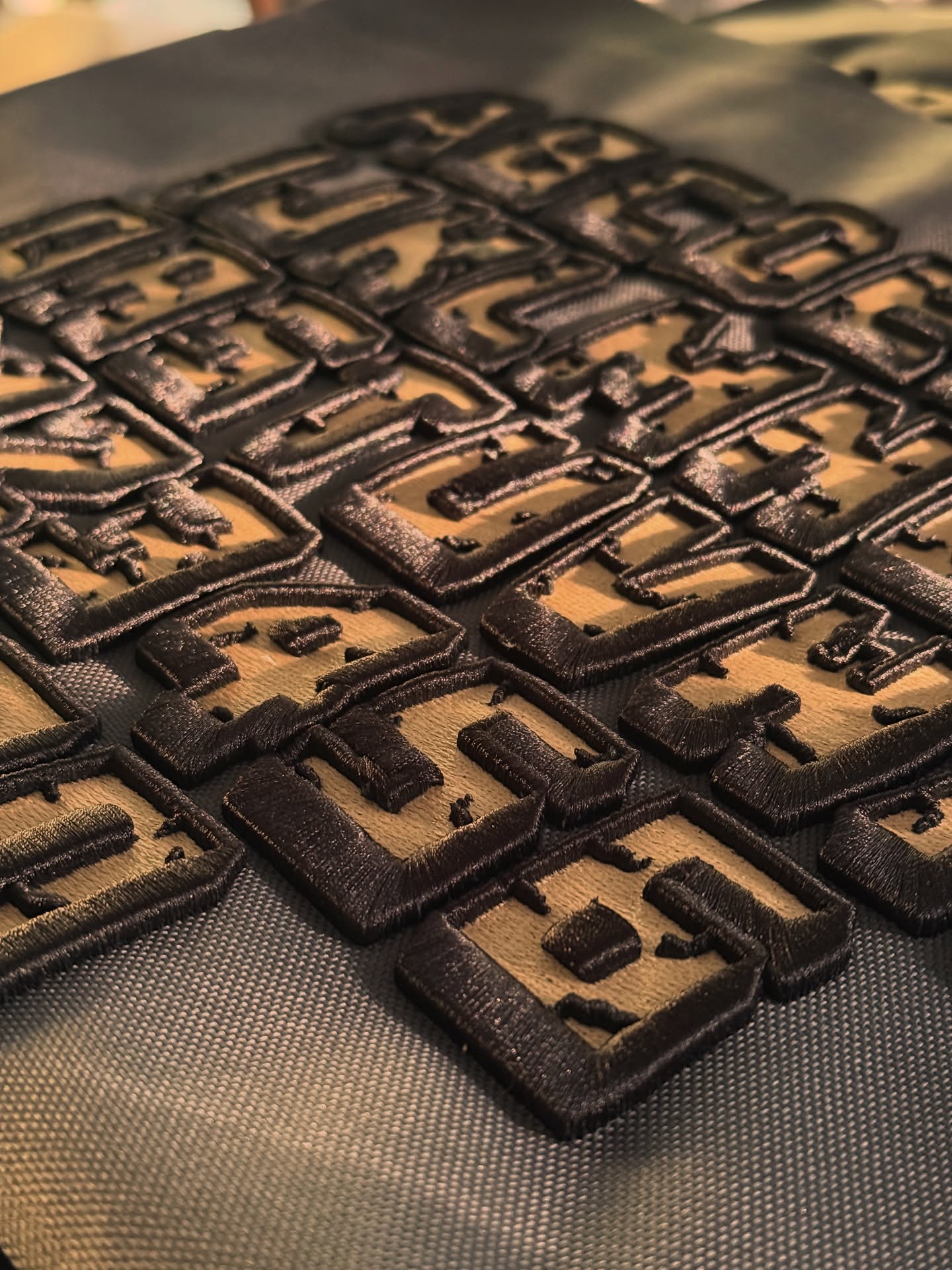 Close-up of textured brown square patches on a black surface