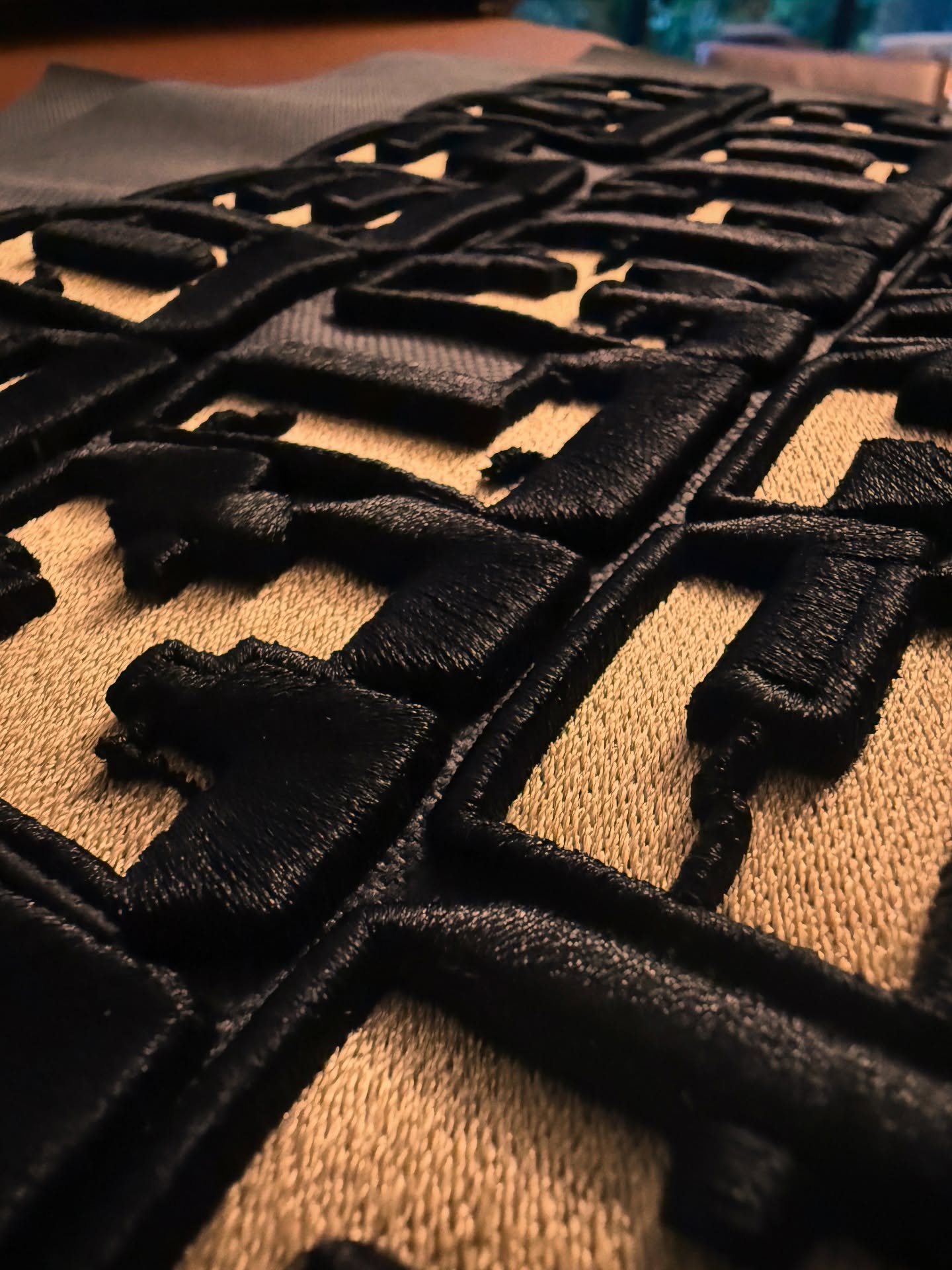 Close-up of a black woven mat on a textured surface