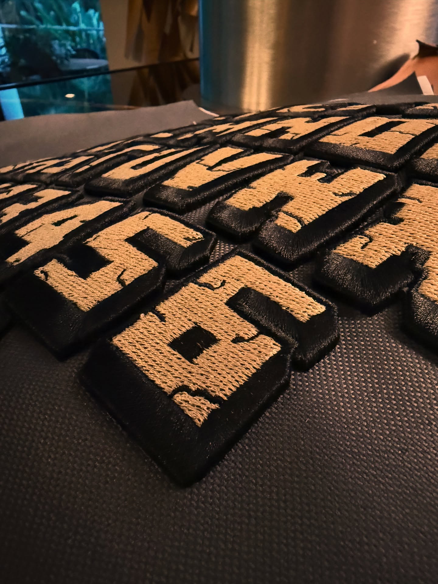 Black and gold patches with text on a textured surface