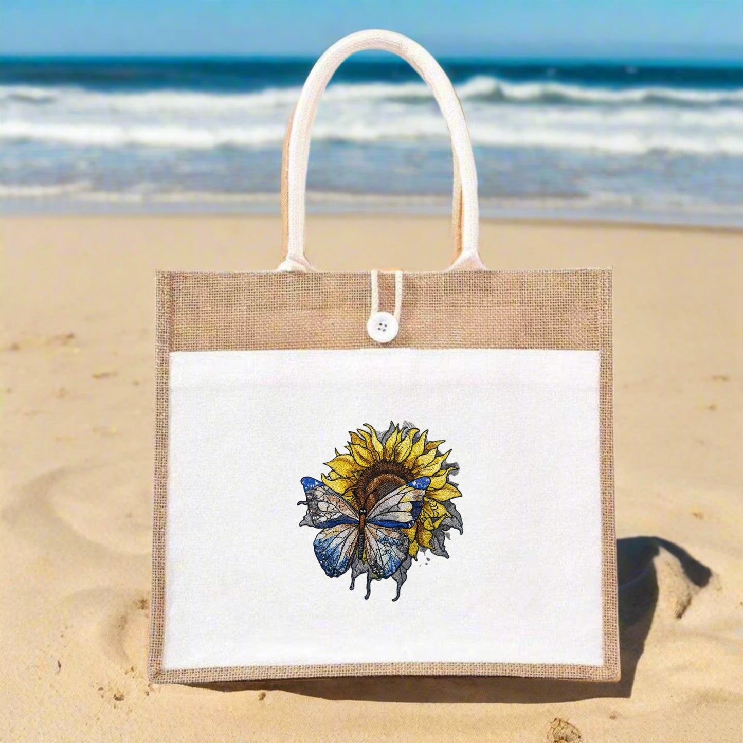 Embroidered jute tote bag featuring a sunflower with a butterfly on it, against a white background.