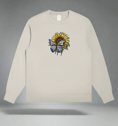 A detailed embroidery design of a sunflower with a butterfly, stitched in various colors on a mint green  sweatshirt.