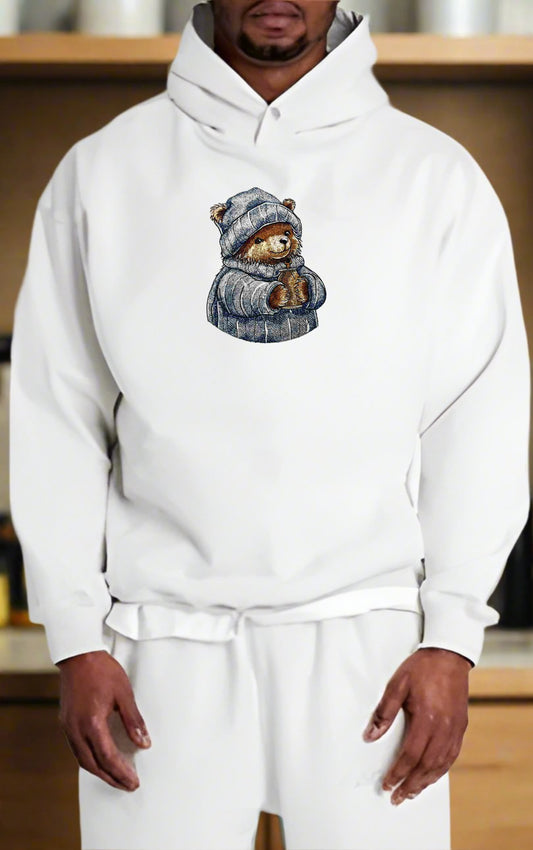 Person wearing a white hoodie with a bear design on a blurred background