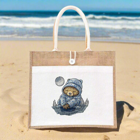 A tote bag with an embroidered design featuring a drowsy sloth in a night setting with stars and a crescent moon.