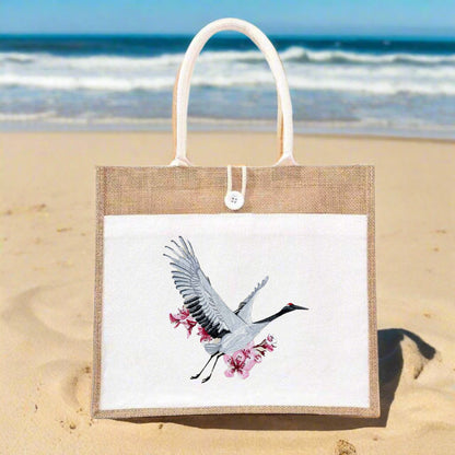 Embroidered jute tote bag featuring a crane bird with cherry blossom designs.