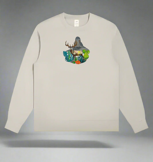 Embroidered crewneck sweatshirt with a design of a mountain deer surrounded by wildflowers and alpine pines against a rainbow-colored background.