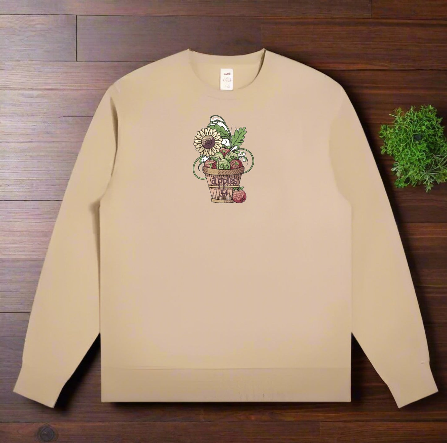 Beige sweatshirt with a floral design on a wooden surface