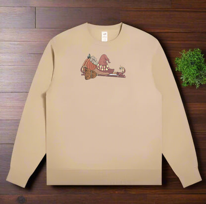 Beige sweatshirt with a If the Broom Fits Ride It Embroidery Design  on a wooden surface
