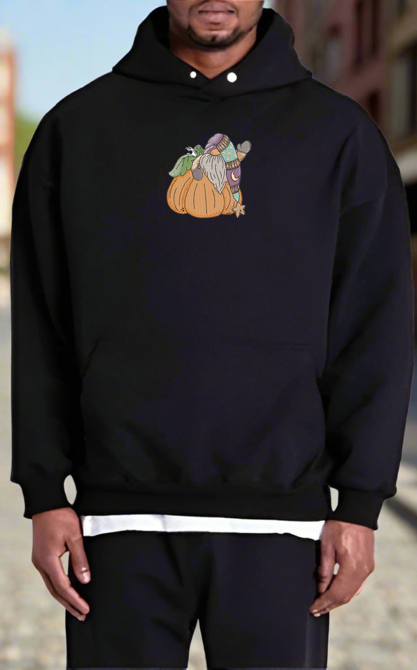 Person wearing a black hoodie with a graphic design of a character on a pumpkin.