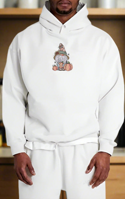 Person wearing a white hoodie with a graphic design on a wooden shelf background