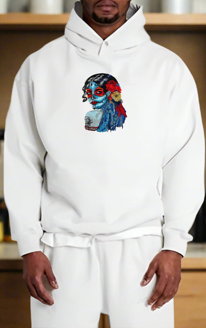 Person wearing a white hoodie with a colorful Sugar Skull Lady Embroidery – Día de los Muertos Art  design on a wooden shelf background