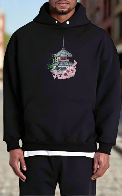 Person wearing a black hoodie with a design on a blurred background