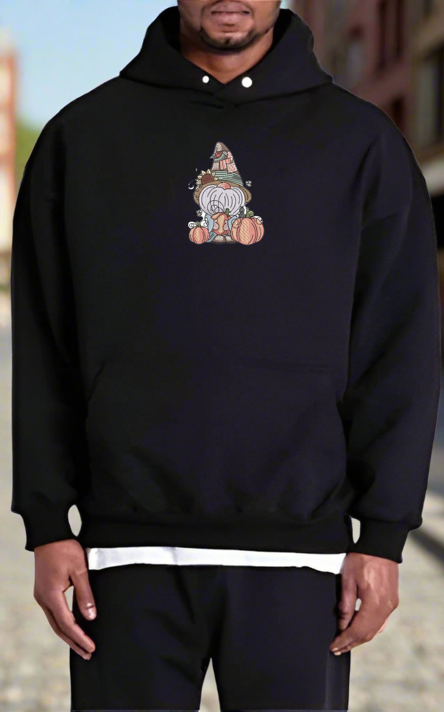 Person wearing a black hoodie with a colorful graphic design on a blurred background