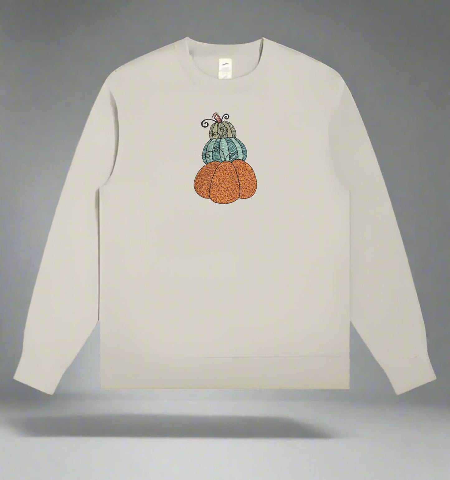 Mint Green long-sleeve sweatshirt with embroidered pumpkins on a gray background