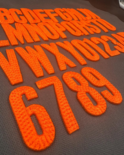 Orange letters and numbers on a brown background
