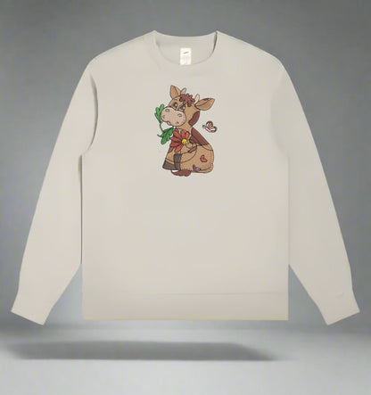Beige sweatshirt with a cartoon cow design holding flowers on a gray background