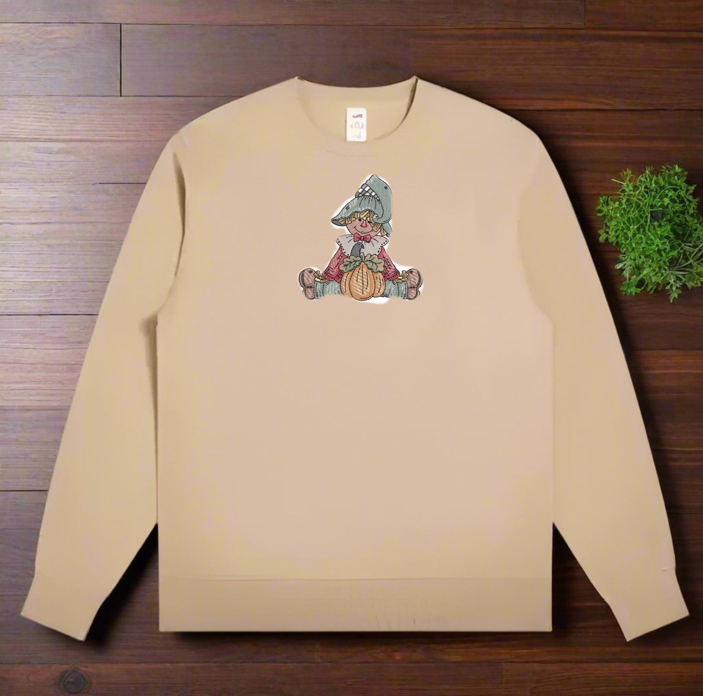 Beige sweatshirt with a graphic of a gnome on a wooden surface