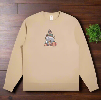 Beige sweatshirt with a gnome graphic on a wooden surface