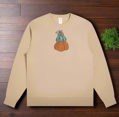 Beige sweatshirt with a pumpkin design on a wooden surface
